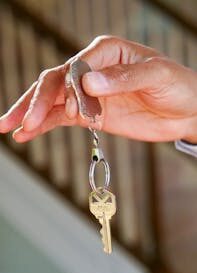 Person Holding a Keychain with Key